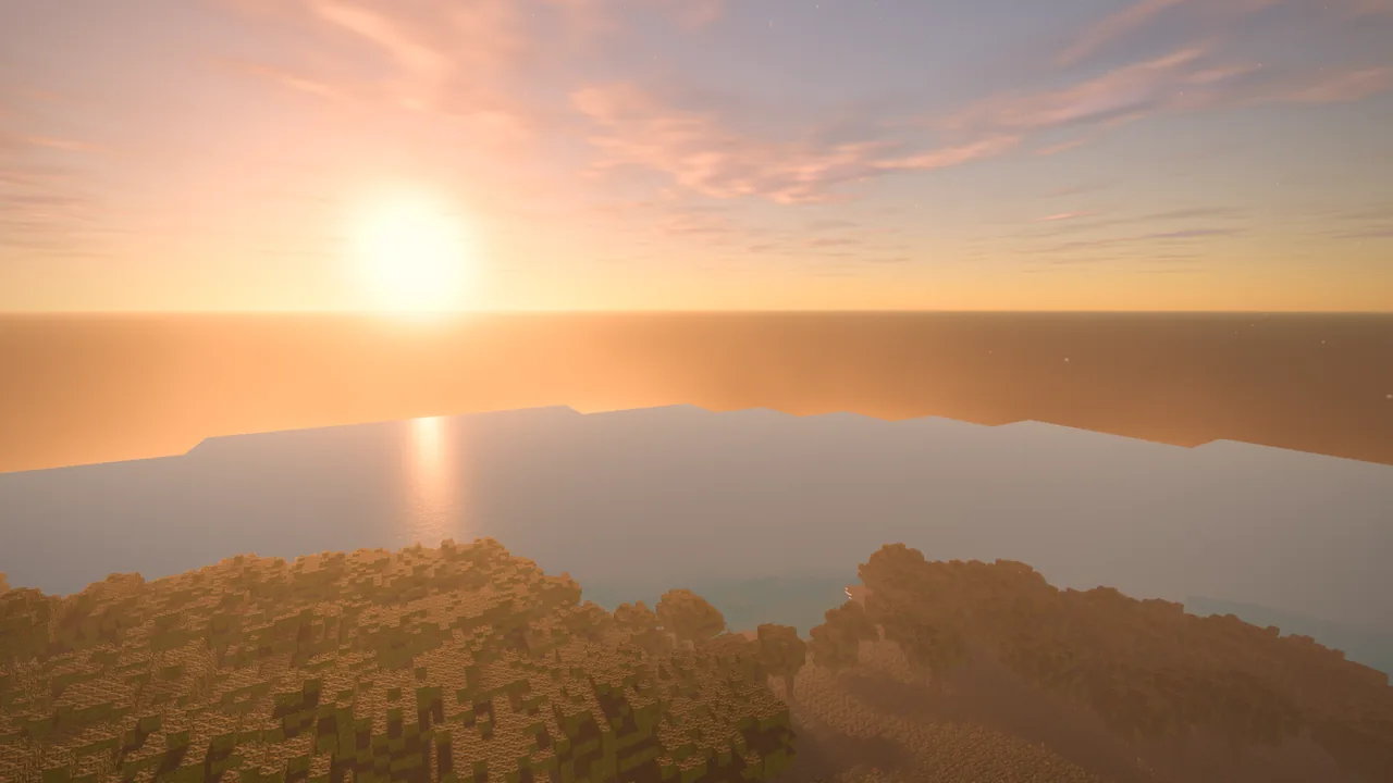 The sun rising over the sea from a wooded coast