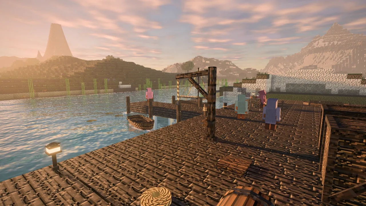 A timber dock with a crane at sunrise, boats and cargo along it