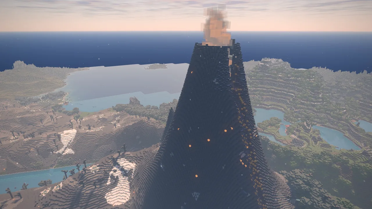 A volcano smoking above lakes and wooded country